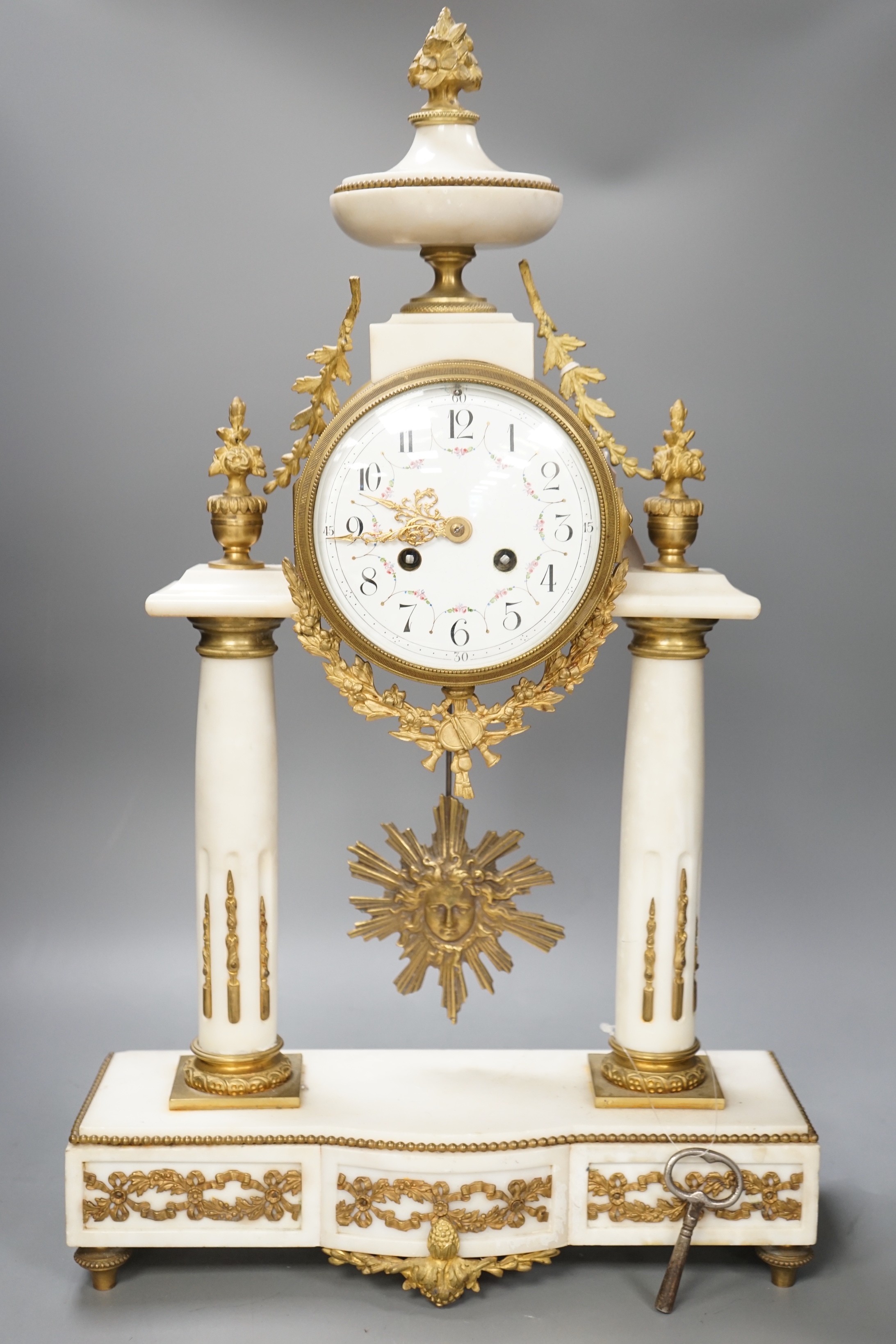 A large French white marble portico clock with ormolu decoration and sunburst pendulum, 59.5cm tall